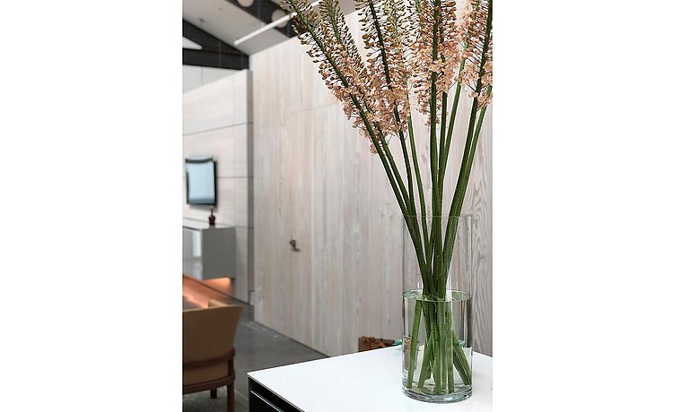 Vignette photo of tall flowers in vase on white quartz island countertop 